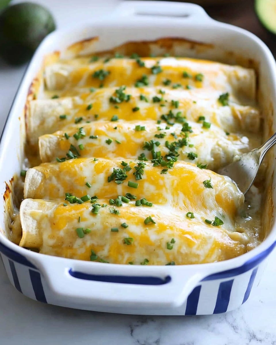 A white baking dish with blue vertical stripes on the side holds four enchiladas placed side by side in one layer, each topped with melted cheese that is a mix of bright orange and creamy white colors. The cheese is slightly stringy and bubbly, covering the soft tortillas underneath. Small bright green chopped scallions are sprinkled evenly on top, adding contrast to the cheesy surface. A woman's hand with a metal spatula is lifting one enchilada from the front of the dish, showing its soft texture. The dish rests on a white marbled surface with a blurred background featuring avocado halves and lime wedges. photo taken with an iphone --ar 4:5 --v 6.1