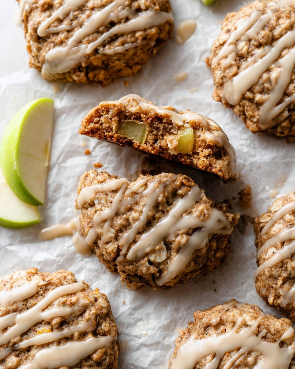 The image shows a white round plate with a decorative edge, holding eight oatmeal cookies with a rough, chunky texture. Each cookie is golden brown with visible oats and nuts, topped with light cream-colored drizzle spread unevenly over the surface. The plate is placed on a white marbled surface. A bit of a green cloth is visible in the lower left corner, and part of a white cup with speckled brown decoration and light brown liquid is seen in the top left corner. Photo taken with an iphone --ar 4:5 --v 7