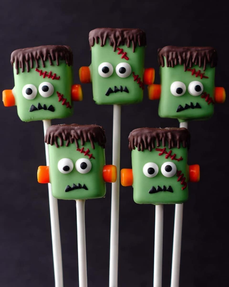 The image shows seven marshmallows decorated as green Frankenstein heads on white sticks, each with smooth green icing covering the marshmallow body. The tops have dark brown icing dripping unevenly to look like hair, with little stitched scars made of red icing on one side. Each face has two large round white eyes with black pupils placed close together and a simple zigzag black mouth near the bottom. On each side of the marshmallows, there are small orange pretzel sticks representing bolts. The background is dark, contrasting with the bright green marshmallows. Photo taken with an iphone --ar 4:5 --v 7