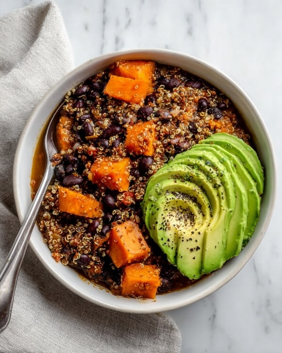 There is a white bowl filled with a layered stew-like dish. The bottom layer shows cooked quinoa mixed with black beans and soft orange chunks, likely squash or sweet potato, creating a textured base of orange and black colors. On top of this base is a dollop of white creamy sauce covered lightly with chopped green cilantro. Beside the sauce are slices of avocado fanned out in smooth, light green layers. Shredded pale yellow cheese is scattered on the surface, adding a thin, slightly curly layer. A silver spoon stands inside the bowl. Around this main bowl, there are two more white bowls showing the same dish, and small bowls holding extra creamy sauce and sliced avocado. The setting rests on a white marbled surface with scattered green cilantro leaves for decoration. Photo taken with an iphone --ar 4:5 --v 7