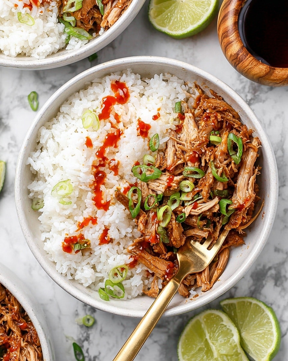 A white bowl filled halfway with fluffy white rice on the right side, with a pile of shredded cooked chicken in a light brown sauce on the left side of the bowl. Thin slices of green onion are sprinkled over the chicken and rice, along with thin red lines of hot sauce drizzled on top. A gold fork rests on the left edge of the bowl with part of the fork under some chicken. Around the bowl are lime wedges in a small bowl, a glass cup with amber liquid, extra shredded chicken and rice in white bowls, and some extra sliced green onion on a white marbled surface. photo taken with an iphone --ar 4:5 --v 7