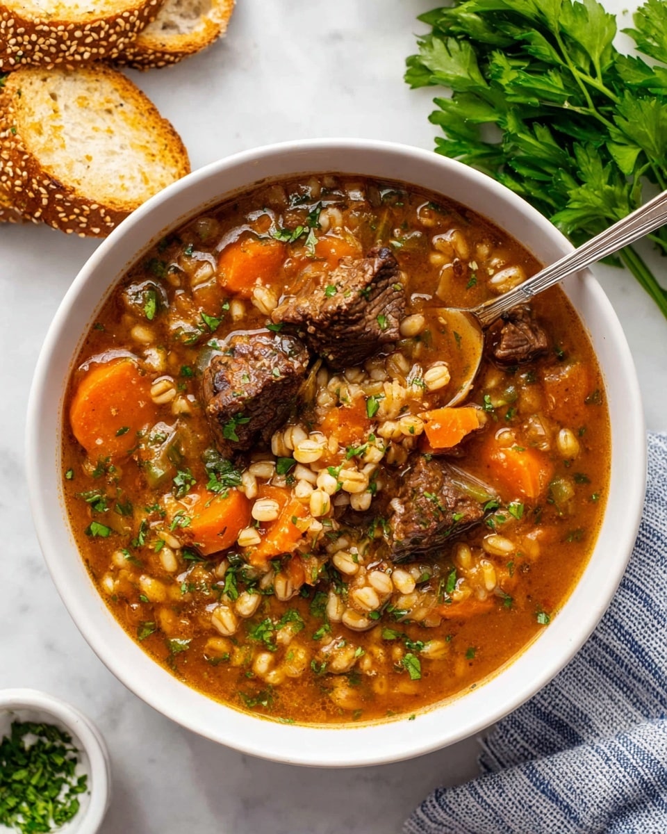 A white bowl filled with a thick soup showing three main layers: the base broth is rich brown and slightly translucent with visible herbs, the middle layer includes orange carrot slices and small beige barley grains, and the top layer has chunks of brown meat sprinkled with chopped green herbs. A silver spoon rests inside the bowl, holding some of the meat, carrots, and barley. Around the bowl on a white marbled surface are toasted sesame-studded bread slices at the top left, a small white bowl with chopped green herbs at the bottom left, fresh green parsley at the top right, and a blue and white striped cloth partially visible at the bottom right. photo taken with an iphone --ar 4:5 --v 7