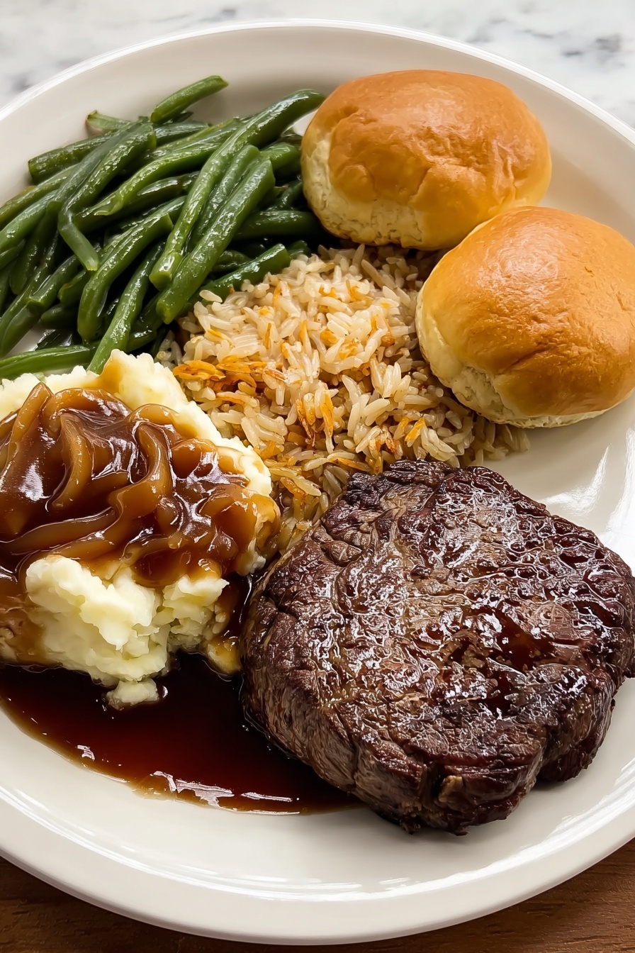 A white round plate holds a meal with five main parts. In the front right is a shiny, brown grilled steak with a slightly uneven charred surface. On the front left are creamy mashed potatoes topped with smooth, dark brown gravy that pools slightly on the plate. Behind the mashed potatoes and steak, there is a heap of green beans, cut into small pieces with a shiny, cooked texture. Above the green beans, there is a serving of rice mixed with small bits of brown lentils or beans, showing a mix of beige and brown colors with a slightly dry texture. On the top right side of the plate, there are two light golden brown dinner rolls with soft and fluffy textures, showing a slight browning on top. The plate rests on a white marbled surface. photo taken with an iphone --ar 2:3 --v 7 - Sweet Soy Butter Beef Tenderloin, beef tenderloin with soy butter, simple beef tenderloin recipe, baked beef tenderloin, flavorful beef dinner