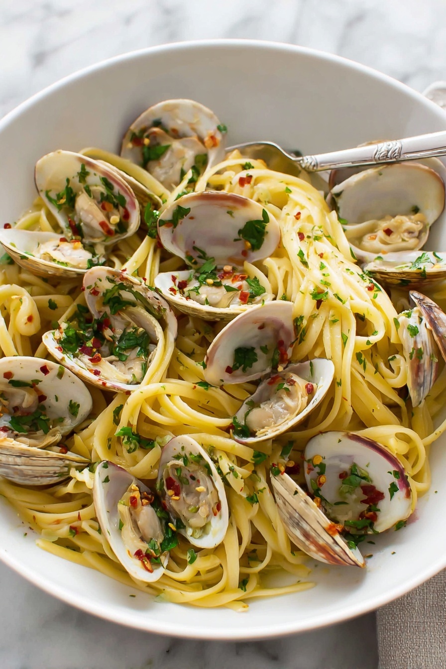 A white round bowl filled with three layers: the base layer is cooked yellow spaghetti pasta twisted into loose nests, the middle layer is light tan clam shells opened with pinkish clam meat inside, and the top layer is chopped green parsley sprinkled evenly with small bits of white garlic and red chili flakes scattered around, with a silver fork placed on the right side resting inside the bowl. The background is a white marbled surface. photo taken with an iphone --ar 2:3 --v 7 - Linguine with Clams in White Wine Sauce, clam pasta recipe, seafood pasta with white wine, quick clam linguine, easy clam pasta dish