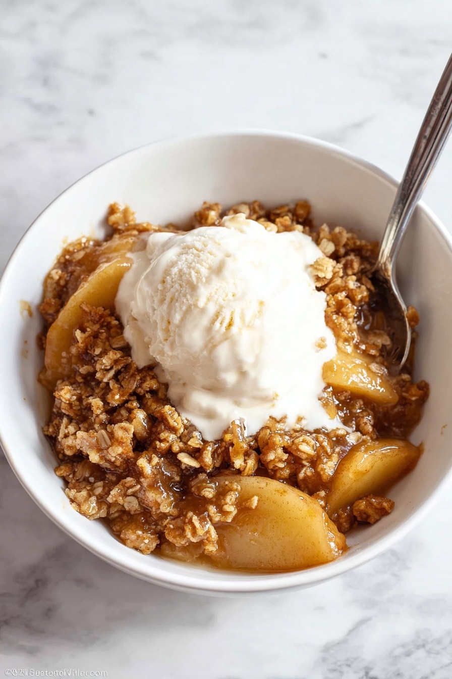 A white bowl filled with warm apple crumble. The bottom layer has soft, golden brown apple slices coated in a shiny, sticky caramel sauce. On top, there is a thick layer of crumbly, light brown streusel made from sugar and oats with a rough texture. The caramel sauce slightly glistens over the crumble, giving a moist and rich look. The bowl is placed on a white marbled surface. photo taken with an iphone --ar 2:3 --v 7 - Apple Crisp, Easy Apple Crisp, Homemade Apple Crisp, Simple Apple Crisp, Best Apple Crisp
