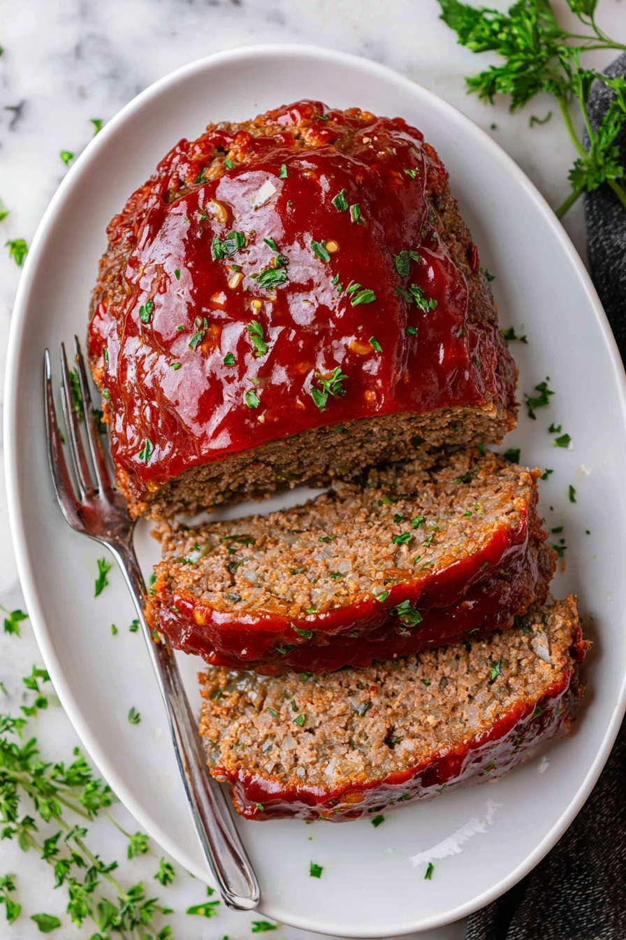 A white plate with three main parts: on the left side, a creamy yellow mashed potato pile with a shiny butter glaze and small green herb bits; in the middle, two thick slices of meatloaf with a rough, crumbly texture and a shiny red tomato glaze with green herbs on top; on the upper side, a group of long, green beans with smooth skin, laid crossing each other. The plate sits on a white marbled surface with a silver fork in the background. photo taken with an iphone --ar 2:3 --v 7 - Classic Meatloaf with Sweet Glaze, tasty meatloaf recipe, easy weeknight dinner, savory meatloaf with sweet glaze, comfort food recipes