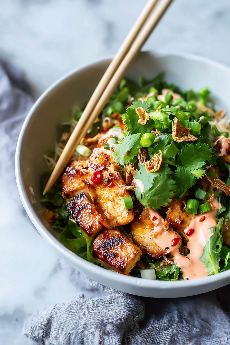 A white bowl holds a colorful dish with several layers starting with golden-brown grilled chicken pieces that have a shiny glaze with small red chili spots, placed at the bottom. On top there is a generous layer of fresh, bright green cilantro leaves and chopped green onions, adding a fresh texture. Some crispy fried shallots are scattered over the greens, and drizzled in spots is a light pink creamy sauce. A pair of light wood chopsticks rest on the rim of the bowl, angled over the food. The bowl sits on a white marbled surface with a soft gray cloth partly visible beside it. Photo taken with an iphone --ar 2:3 --v 7 - Sticky Glazed Tofu Bowl with Yum Yum Sauce, tofu bowl recipes, vegetarian Asian dinner, easy tofu stir-fry, flavorful plant-based bowls